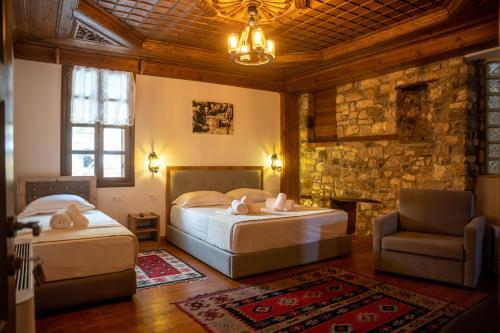培拉特Hotel Kapllani的一间卧室配有两张床、一把椅子和一张沙发
