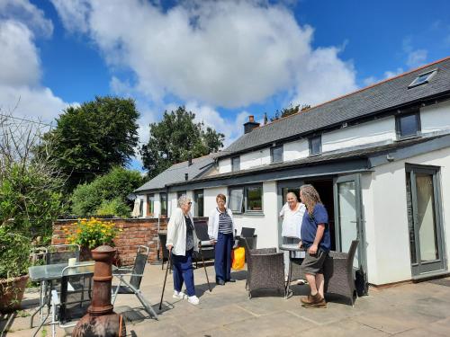 ChallacombeLongstone Luxury Country Boutique Two Bedroom Cottage, Exmoor, Challacombe, North Devon的一群站在房子外的人