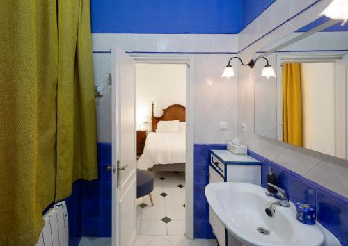 赫雷斯-德拉弗龙特拉PALACIO DON CARLOS的蓝色和白色的浴室设有水槽和镜子