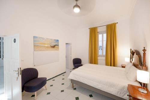 赫雷斯-德拉弗龙特拉PALACIO DON CARLOS的酒店客房,配有一张床和两把椅子
