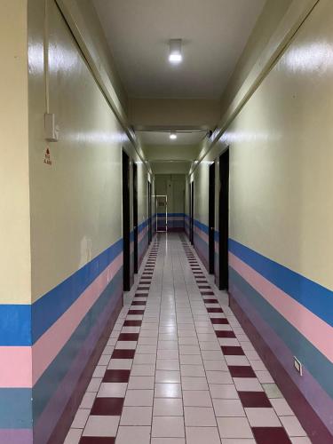 塔比拉兰Pantawan Guest House的墙上有彩色条纹的建筑里空的走廊