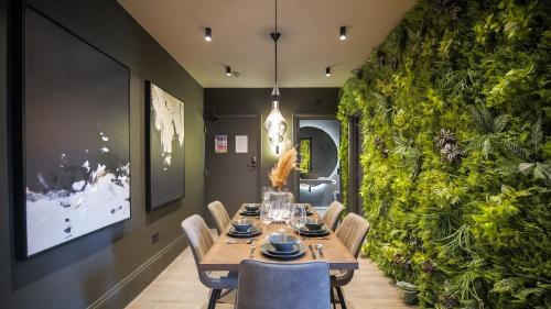 曼彻斯特Midnight by The Heim Residences的一间配备有桌椅的用餐室和绿色的墙壁