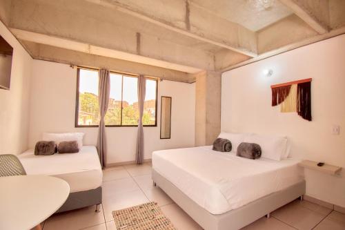 麦德林MANGATA LIVING的一间卧室设有两张床、一张桌子和窗户。