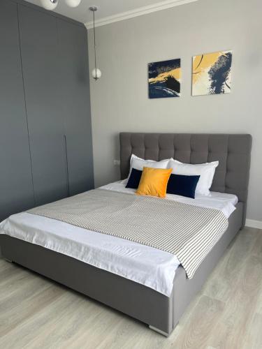 PrigorodnyyАренда квартиры 2的一间卧室配有一张带橙色和蓝色枕头的大床