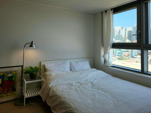 釜山Hot place的卧室配有白色的床和窗户。