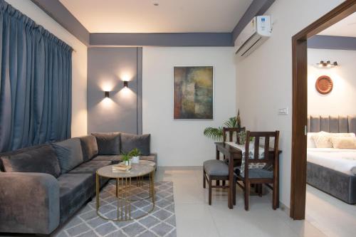 古尔冈Serviced Apartment near Medanta by BedChambers的客厅配有沙发、桌子和床。