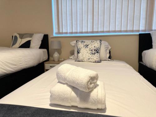 科尔切斯特City Stay的一间卧室配有两张床,床上配有毛巾