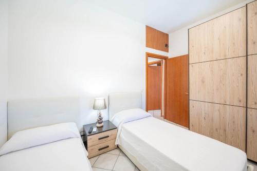 马帝斯兹罗LatoMare - VIBRA的一间卧室配有两张床和一张带台灯的桌子