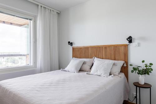 坦佩雷Tower Cabin的一间卧室配有一张带白色床单的床和一扇窗户。