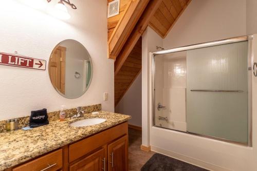 班纳埃尔克Elk Ridge Lodge的带淋浴、盥洗盆和镜子的浴室