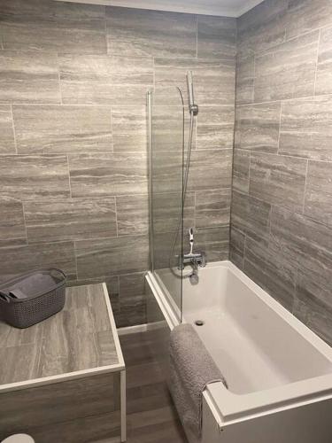 ShephallCosy 1 Bed Home @Stevenage的带浴缸、桌子和淋浴的浴室
