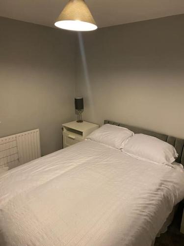 ShephallCosy 1 Bed Home @Stevenage的卧室配有一张带灯的白色大床