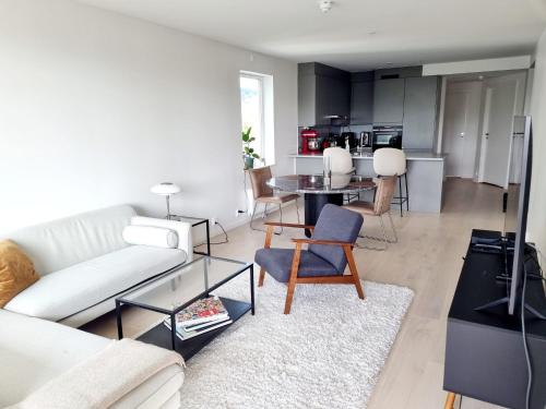 奥斯陆Private room in shared Modern Apartment - Oslo Hideaway的客厅配有白色的沙发和桌子