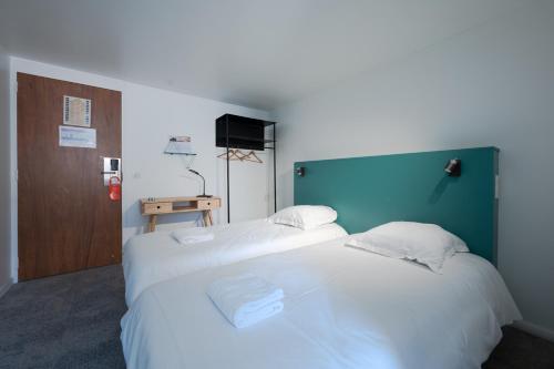 Saint-Aubin平衡骑士酒店的配有白色床单的酒店客房内的两张床