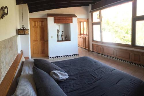 迪坡斯特兰Acogedora Villa con alberca climatizada en el centro de Tepoztlán的一间卧室设有一张大床和一个大窗户