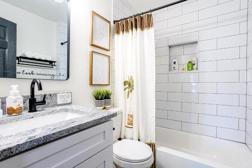 法默斯布兰奇Living in a Greenhouse - City Retreat - 3BR with 70 inches TV的白色的浴室设有水槽和卫生间。
