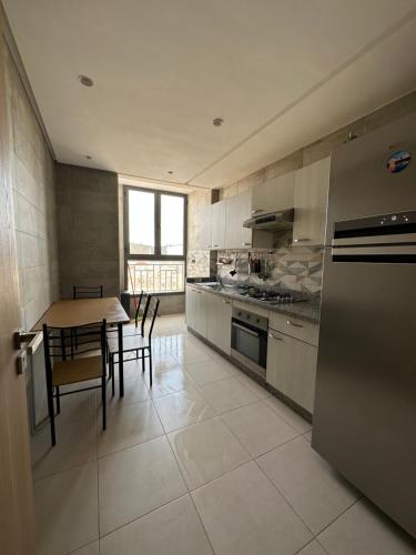阿加迪尔Luxueuse appartement的厨房配有桌子、炉灶和桌椅