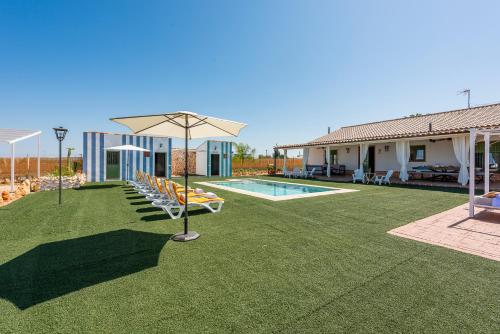 Casa Rural Reifs的一个带游泳池和遮阳伞的庭院