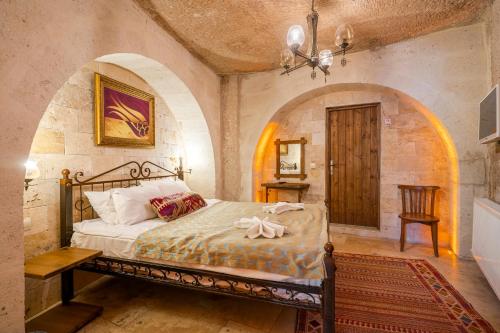 格雷梅Nomads Cave Hotel & Rooftop的一间带一张床铺的卧室,位于一个拱形的房间