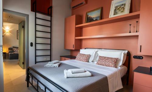 雅典Villa Hermes in Anafiotika Athens !的一间卧室配有带橙色墙壁和书架的床