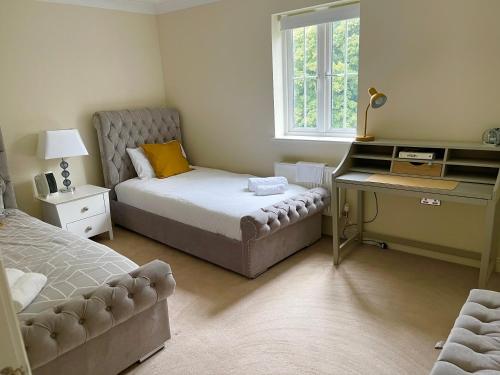 翰索Large Executive 4-Bed Detached House in Miskin, Cardiff-sleeps up to 10的一间卧室配有一张床、一张桌子和一张四柱床。