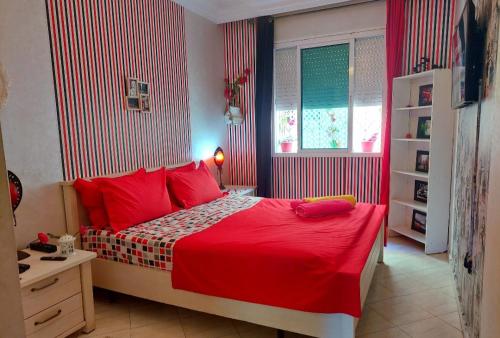 杰迪代StayHere, Nice Apartment with Garden View in center, 1 min walk From Beach的一间卧室配有一张带红色床单的床和一扇窗户。