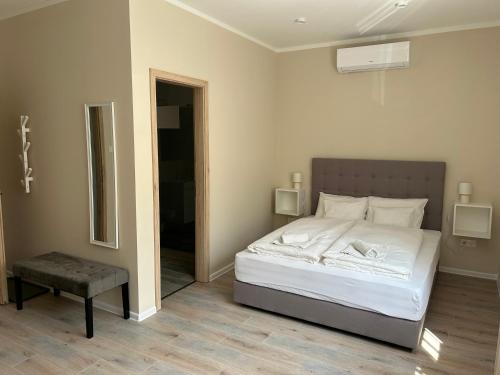 佩奇H30 Apartman的卧室配有白色的床和镜子