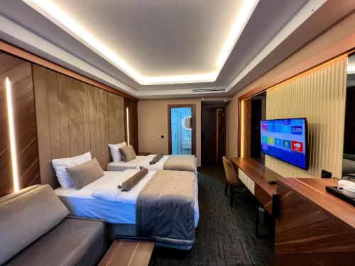 伊斯坦布尔THE PARK HOTEL的酒店客房设有两张床、一张桌子和一台电视。