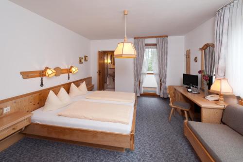 希尔波尔特施泰因森德斯道菲酒店的一间卧室配有一张床和一张带电脑的书桌