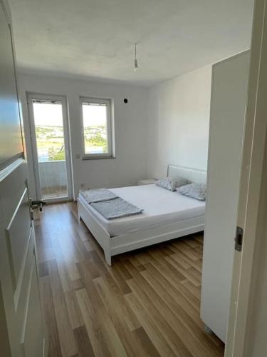 米特罗维察Apartment in Mitrovicë, Kosovë的白色的客房设有一张床和两个窗户。