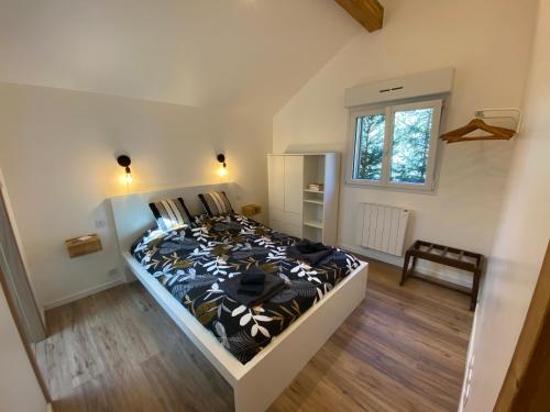 热拉梅Duplex le Corten, Terrasse et jardin的一间卧室配有一张带黑白色棉被的床