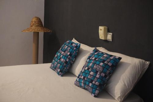 OuidahAu cœur de Ouidah 2的两个枕头坐在床头灯旁