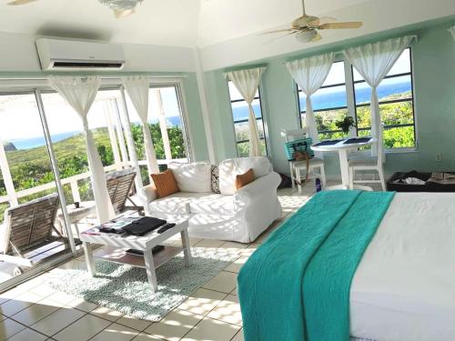Conch BarDragon Cay Resort Mudjin Harbour的一间卧室配有一张床、一张沙发和窗户。