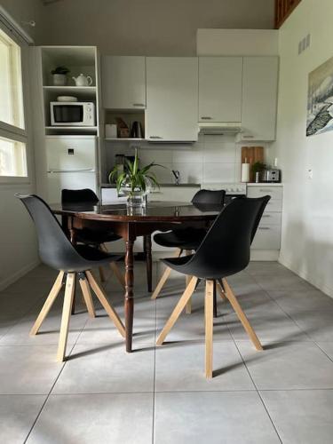 沃卡蒂Tyylikäs koko perheen huoneisto的厨房配有木桌和黑色椅子