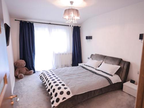 苏恰瓦ASE Premium House的一间卧室配有一张带蓝色窗帘和泰迪熊的床。