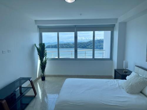 普拉亚伯尼塔村17E Beautiful 2-Bedroom Ocean View Apartment的卧室设有白色的床和大窗户