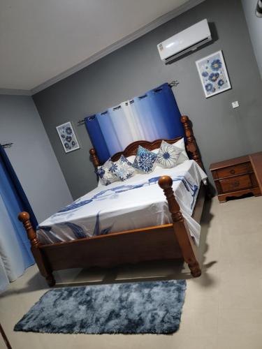 蒙特哥贝victory Luxury Suites的一间卧室配有一张蓝色天蓬床