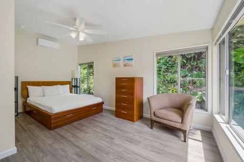 卡内奥赫@ Marbella Lane - Sunshine Seascape Ocean View的一间卧室配有一张床、一把椅子和窗户。