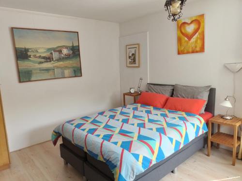 哈伦Kop vd Hondsrug1的卧室配有一张床,墙上挂有绘画作品
