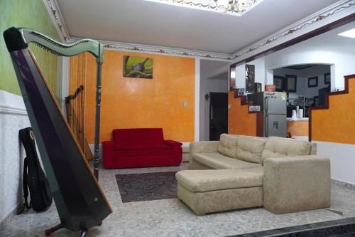圣何塞德尔瓜维亚雷Hostal Castañeda的带沙发和红色椅子的客厅