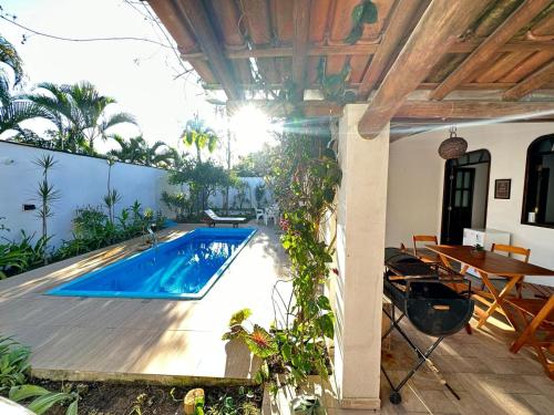 阿拉亚尔达茹达Casa Tropical Arraial D' Ajuda的庭院中间的游泳池,带桌子