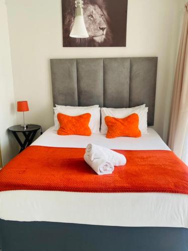 比勒陀利亚The blyde-Luxury one bedroom apartment的一间卧室配有带橙色和白色枕头的床