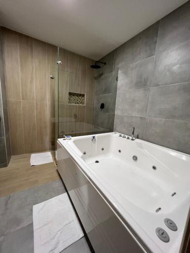 布卡拉曼加布埃纳文图拉快捷酒店的带淋浴的浴室内的白色大浴缸