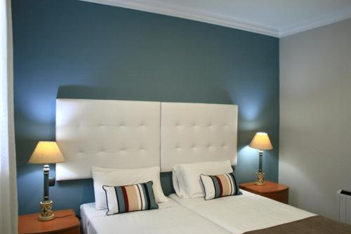 大加那利岛拉斯帕尔马斯Las Canteras Beach的一间卧室配有一张带白色床头板的床和两盏灯。