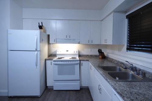 安克雷奇410 E 45th Unit 1的白色的厨房配有白色冰箱和水槽