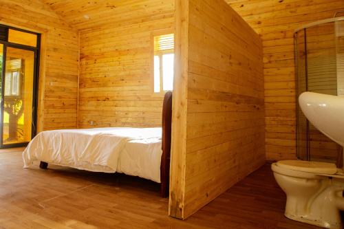 Maravilla Kivu Eco Resort的卧室配有木墙内的一张床
