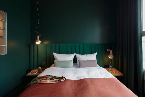 多特蒙德Basecamp Hotel Dortmund的一间卧室设有一张大床和绿色的墙壁