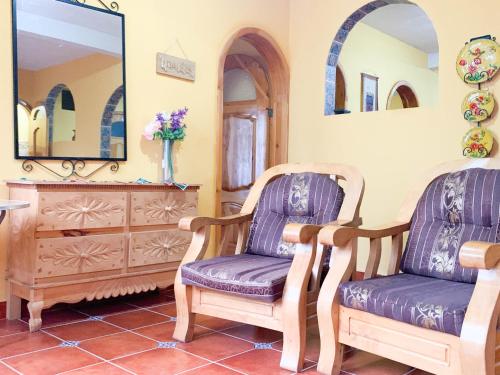 帕纳哈切尔Casa Esperanza的一间设有两把椅子、梳妆台和镜子的房间