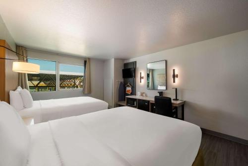 尤巴城尤巴城旅程住宿酒店的酒店客房设有两张床、一张桌子和一面镜子