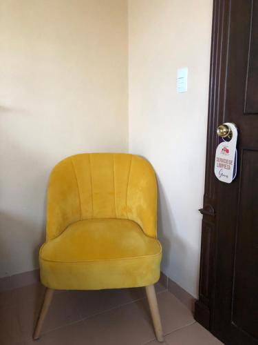 科苏梅尔Villas Segovia Hotel Boutique & Suites的坐在门边角落的黄色椅子